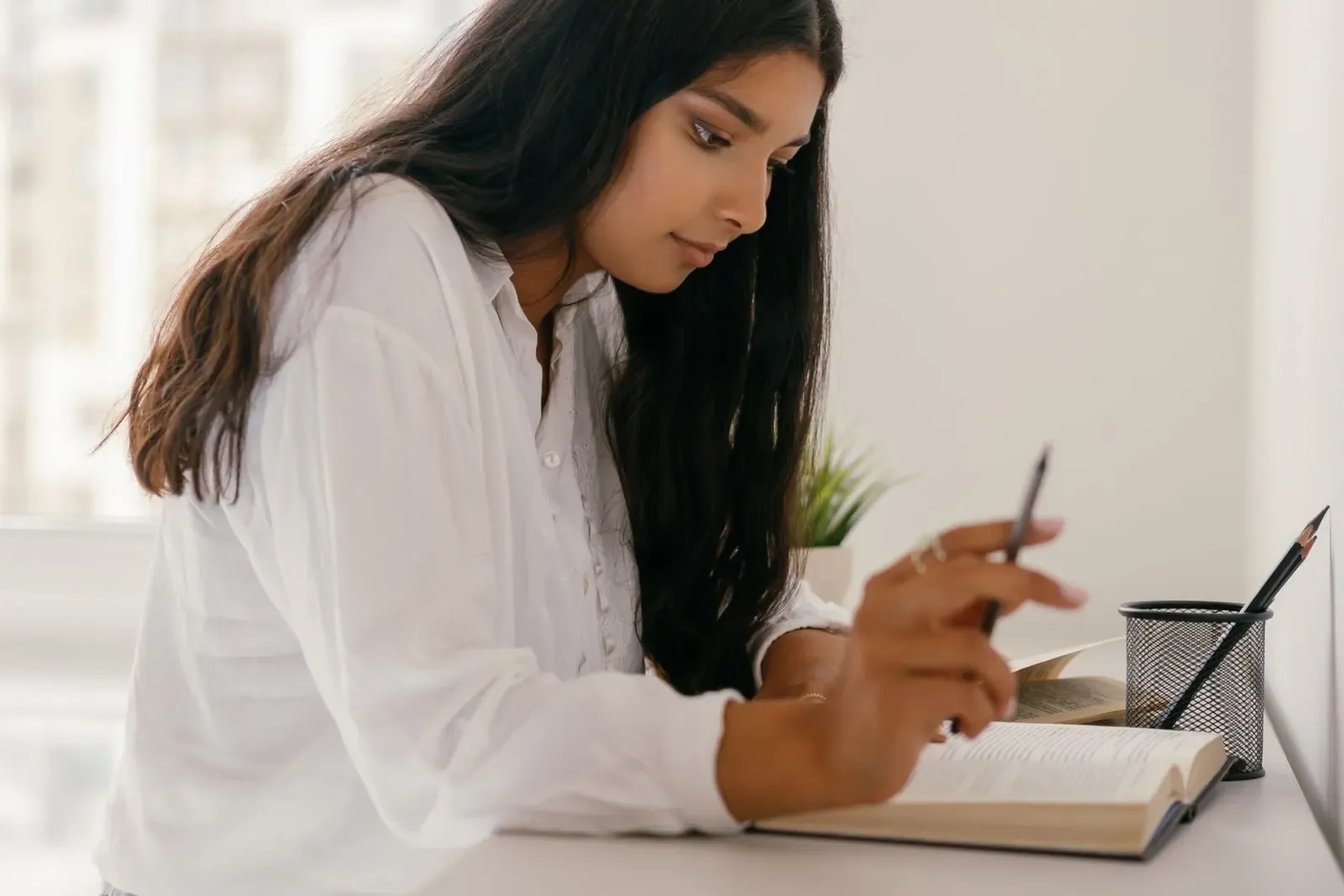 Estudiante de bachillerato tomando notas junto a sus libros
